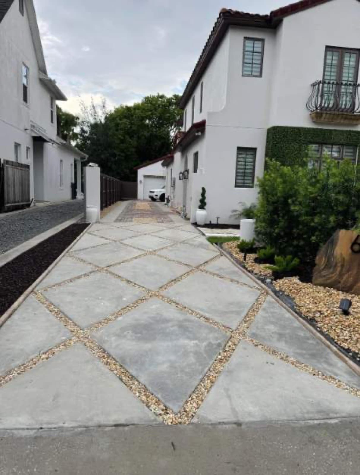 Diamond-pattern concrete driveway with gravel inlay at Central Florida home — Firsthand Lawn and Landscape