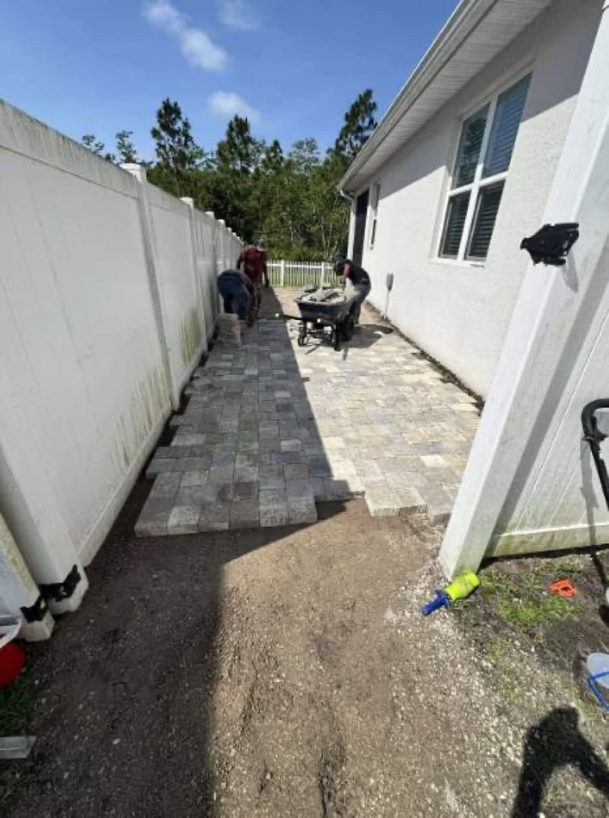 Crew installing paver walkway along side yard in Central Florida — Firsthand Lawn and Landscape